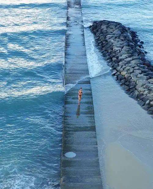 high angle view of pacific islander woman running on wooden pier