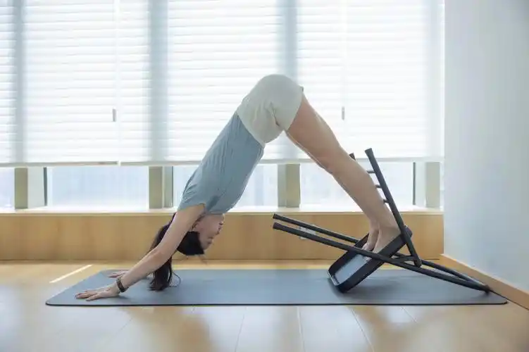 艾扬格椅子上的下犬与脊柱前屈