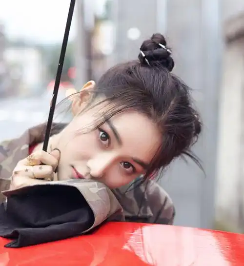 张馨予的双丸子头是将头发先拧成一股后再盘起来,还加入了一些小发饰