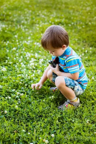 在草地上玩耍的小男孩