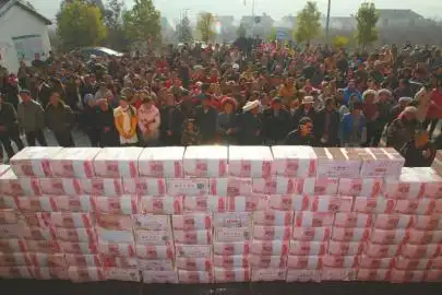 现场,重达312斤的人民币现金一捆捆整齐地放在台上,340余户入股村民