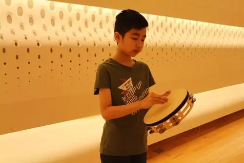 持鼓,鼓皮朝上,大拇指紧贴鼓皮表面,其他四个手指紧紧握住铃鼓的框架