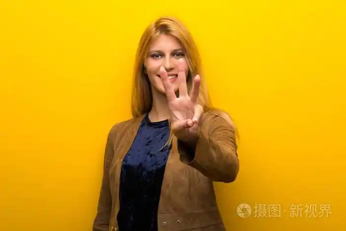 金发女孩在充满活力的黄色背景下快乐地数着三个手指