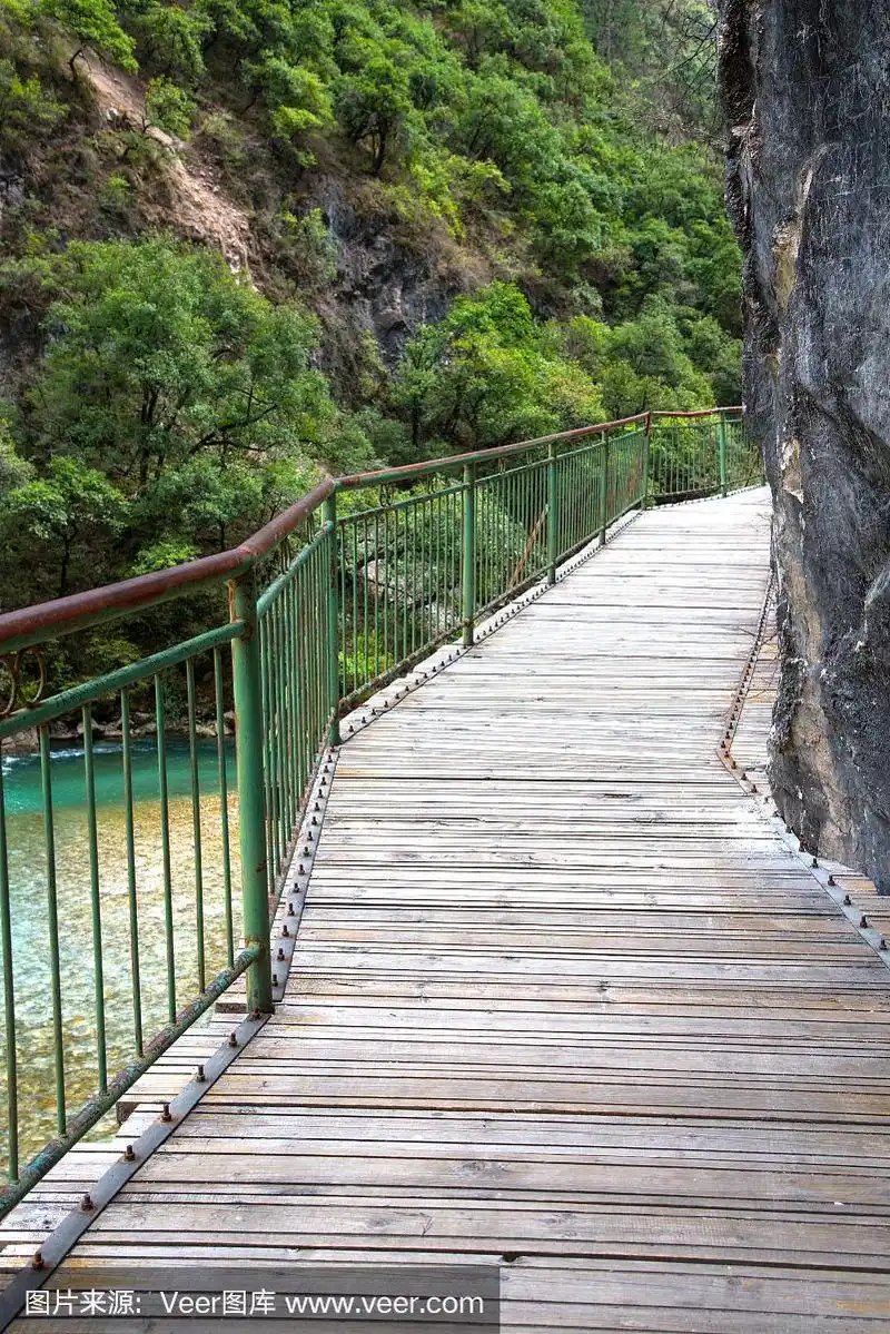 在中国香格里拉市的巴拉格宗国家公园,一座长长的木桥悬在悬崖上和河