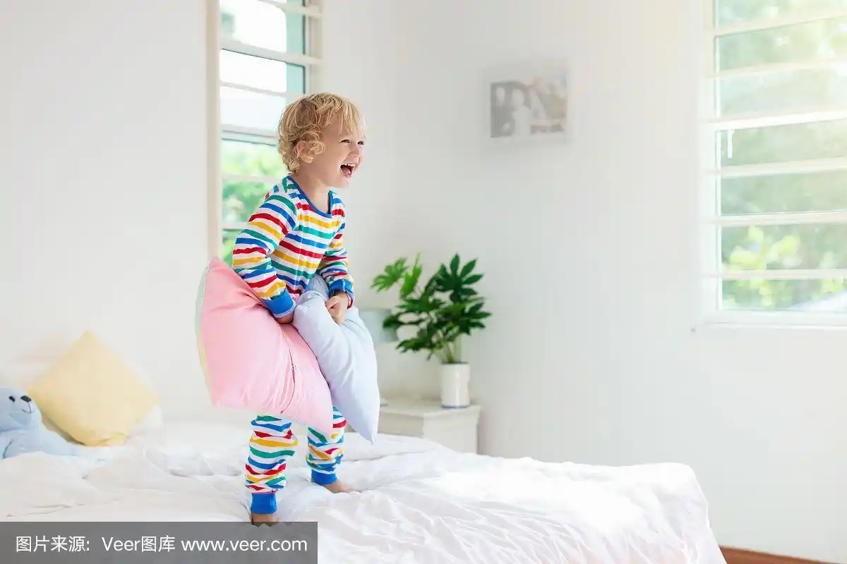 孩子在床上玩耍.孩子的房间.小男孩在家.