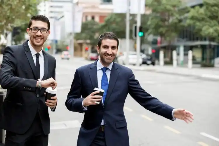 城市街头推着自行车交谈的两个年轻的商人