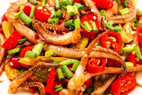 一盘香辣鱿鱼须放在白底上