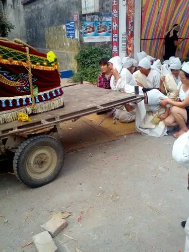 死者的两个儿媳妇披麻戴孝送灵车