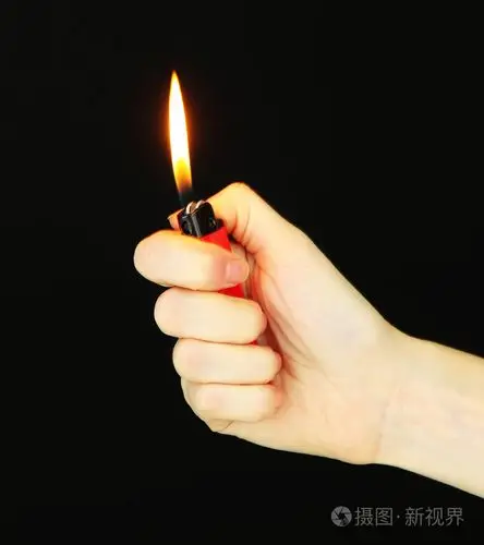 在女性手中燃烧打火机孤立在黑色
