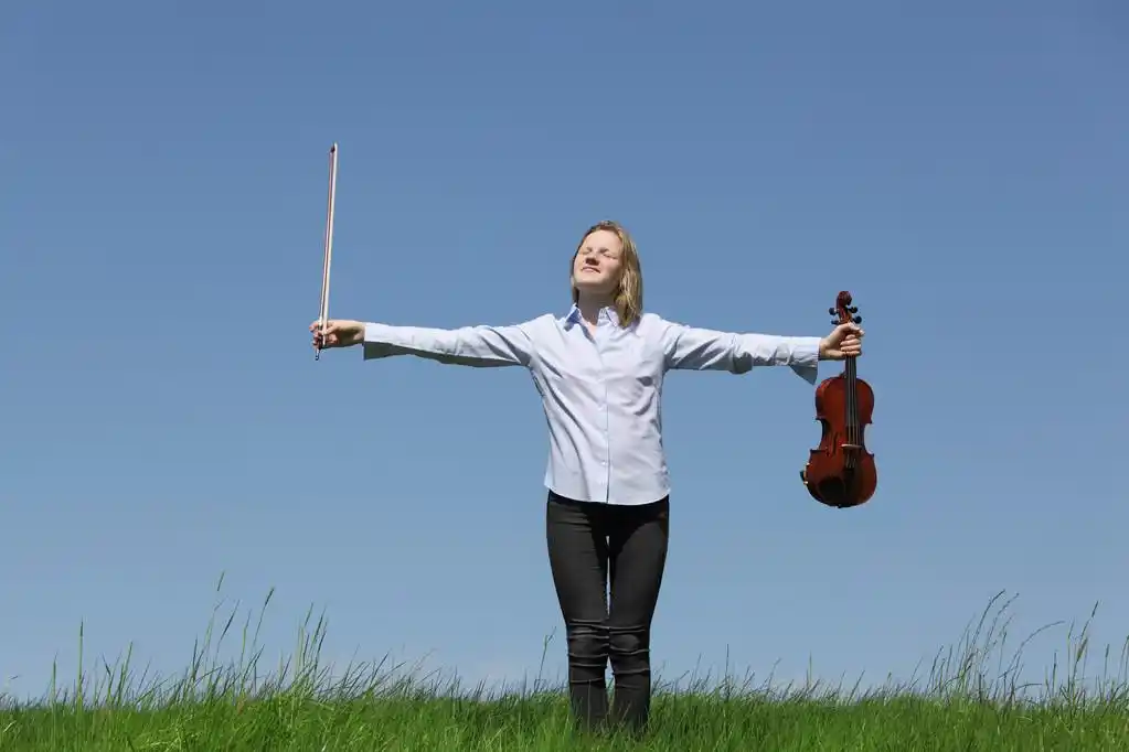 小提琴的女孩,在蓝蓝的天空草地上拉小提琴的少女
