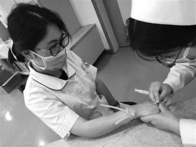 带教护士俞莹芳伸出右手让实习生练习扎针 通讯员供图