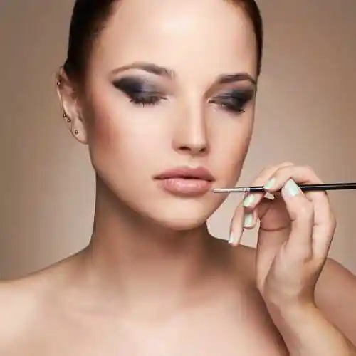 化妆师拿着化妆刷为模特化妆