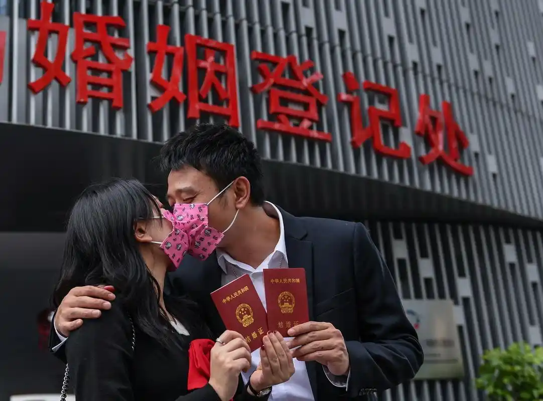 2月14日,在深圳市南山区民政局婚姻登记处前,完成结婚登记的邓玲玲(左