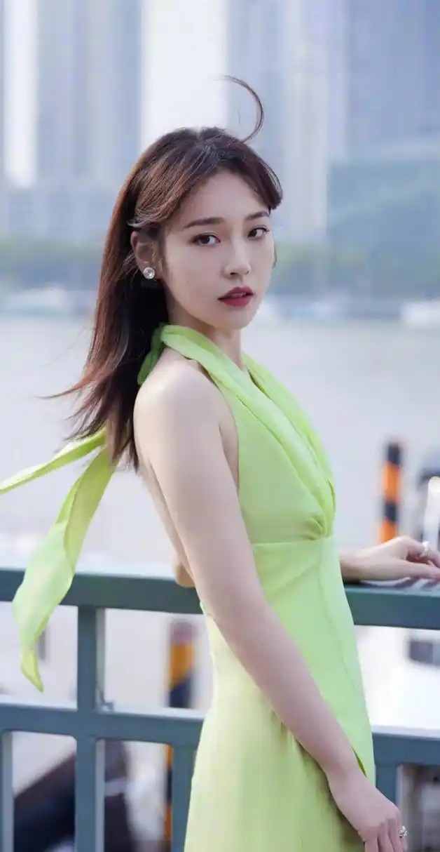 牛油果绿挂脖长裙的选择展现出了她的清新风格,开叉