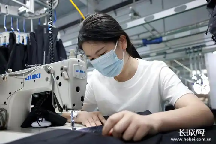 邢台市南和区郝桥镇宣宏制衣服装厂的工人正在缝制衣服.通讯员耿昭摄