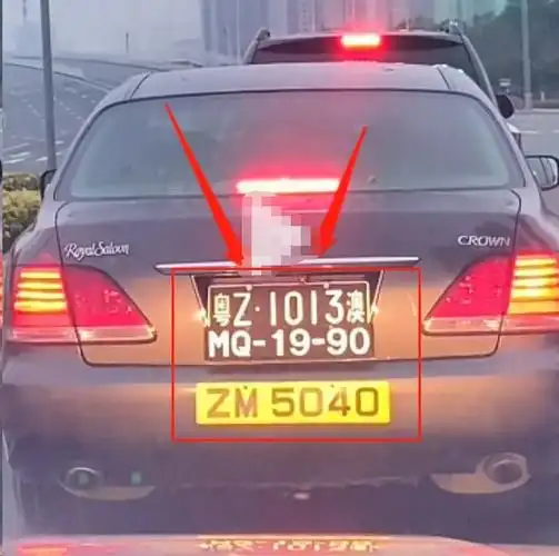 这辆丰田皇冠的车尾上挂着三块车牌,其中有两块黑色车牌,还有一块黄色