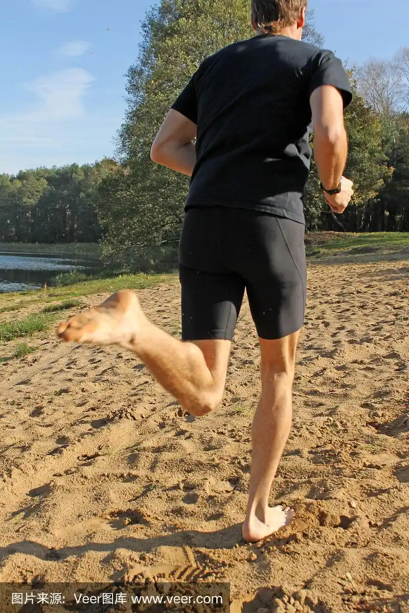 赤脚男人在沙滩上奔跑