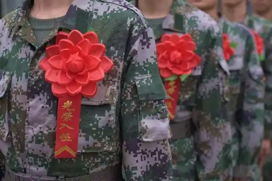图为入伍新兵佩戴的"光荣入伍"大红花