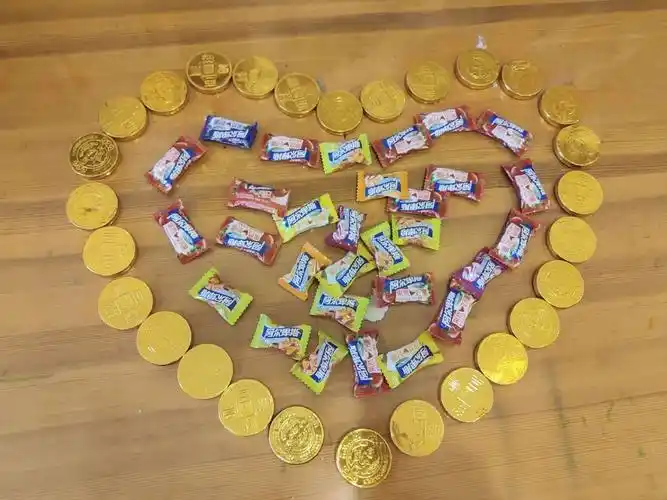 把最爱的巧克力和糖果摆出爱心的形状,我们浓浓的爱意你收到没