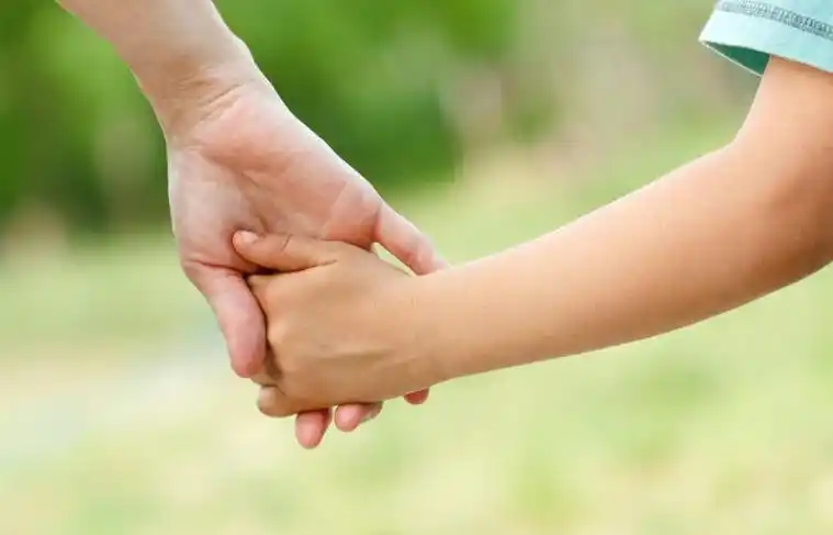 阳光下孩子拉着爸爸的手