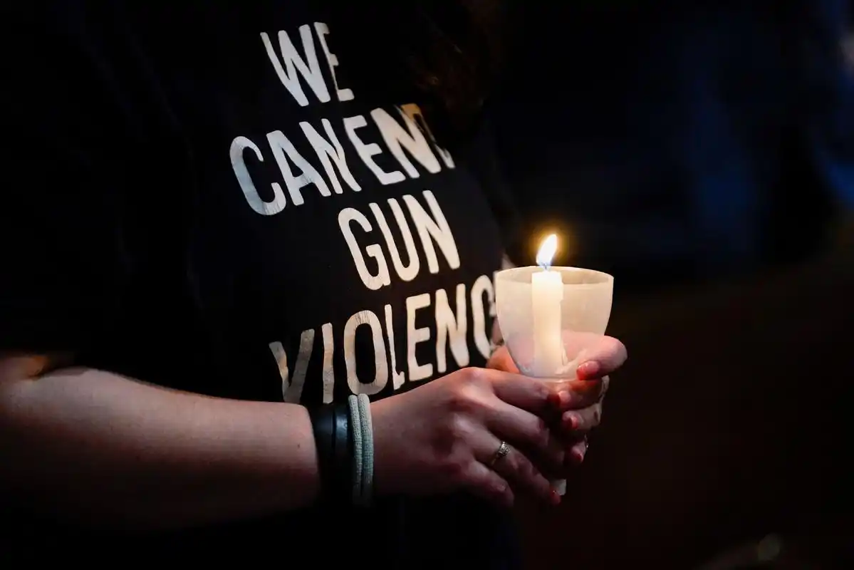 5月26日,在美国康涅狄格州纽敦市,一名女孩手持蜡烛哀悼枪击事件遇害