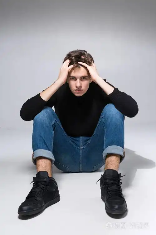 全白底男学生肖像.摄影棚拍到英俊迷人的欧洲男人坐在地板上