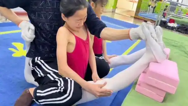 男老师坐在女孩胯部强制压腿,女孩反应太可怜,网友怒批过分|体育老师