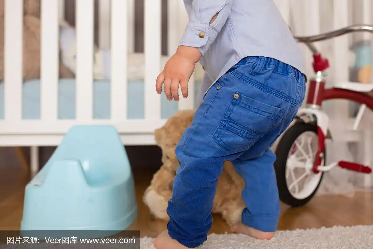 一个蹒跚学步的小男孩,尿在裤子里,没能按时上厕所