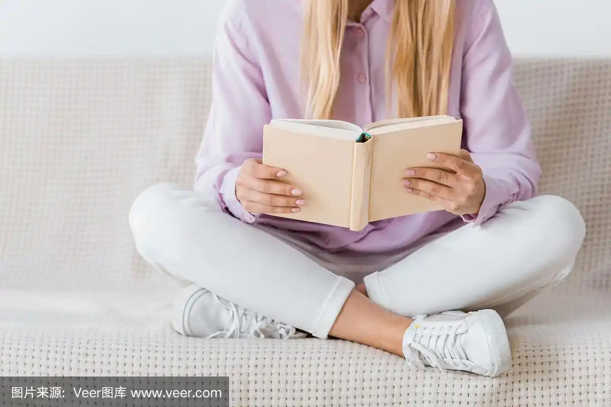 一个女人翘着腿坐在沙发上看书