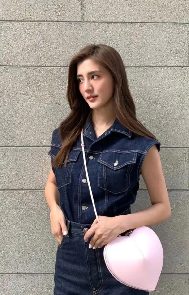 吴千语倚靠在墙边摆pose,她的粉色心形包包很亮眼,鞋子更是时尚感满满