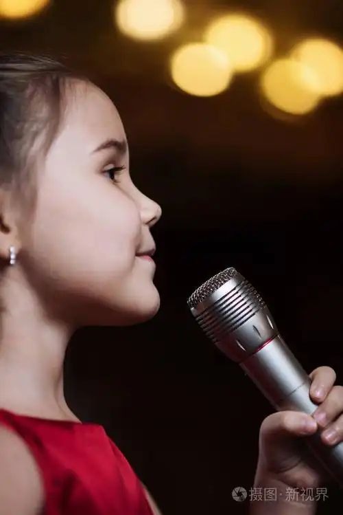 拿着麦克风的女孩.一个小孩唱卡拉 ok 特写镜头