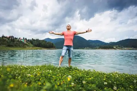 一个人独自站在塞尔维亚的 zaovine 湖上紧握双手, 感受自由照片