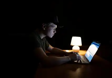 晚上加班的男人男人晚上在笔记本电脑上工作照片