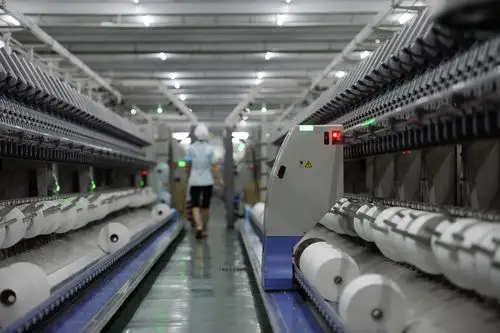 在江苏苏州盛泽镇京奕集团的涡流纺车间,"落纱机器人"在工作(2016年8