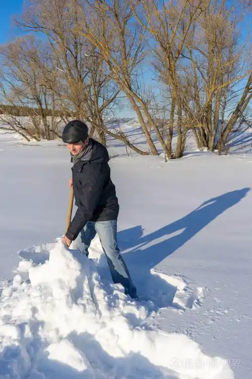 一个拿着铁锹的人从乡下的房子铺到马路上.冬季主动休闲理念