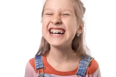 小孩矫正牙齿小女孩带着洁白背脊上的矫正器照片