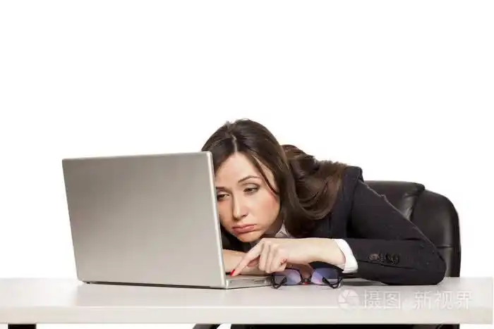 在办公桌前工作的年轻疲惫的商务女性笔记本电脑