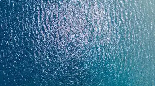 挥动海面俯视照片. 热带岛屿船旅行. 游轮小径. 蔚蓝的海洋表面俯视.