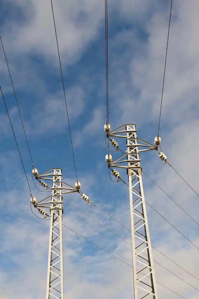 蓝蓝的天空和云下的高压电线杆