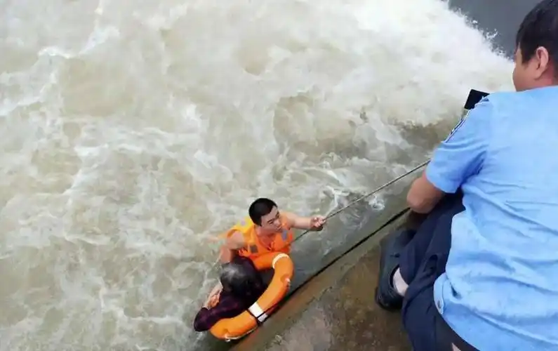绑在老人身上的救生绳 终于将老人从河中救起 经现场医护人员诊断