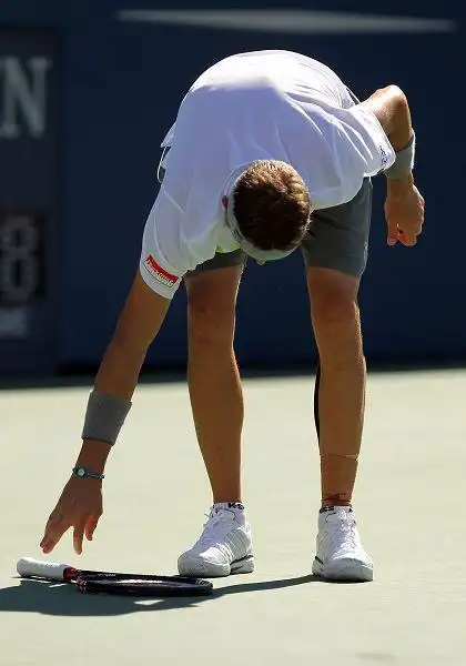 费什弯腰捡球拍