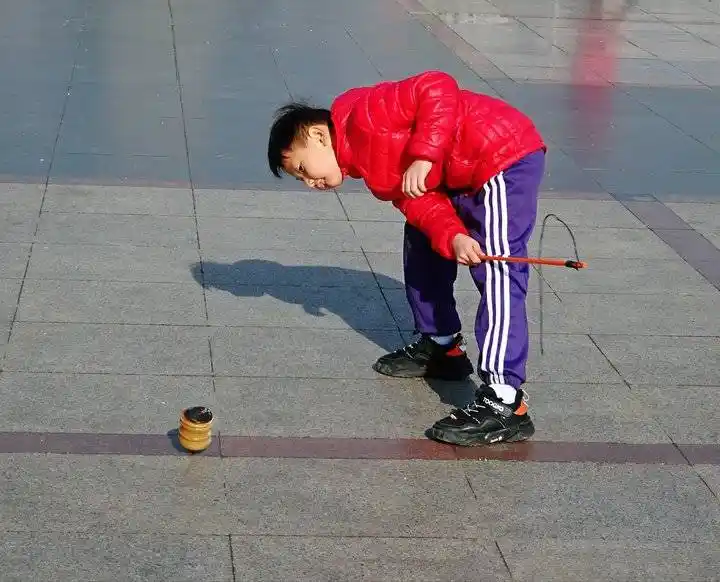 周末济南风和日丽暖如春,洪家楼广场上老少同乐抽陀螺