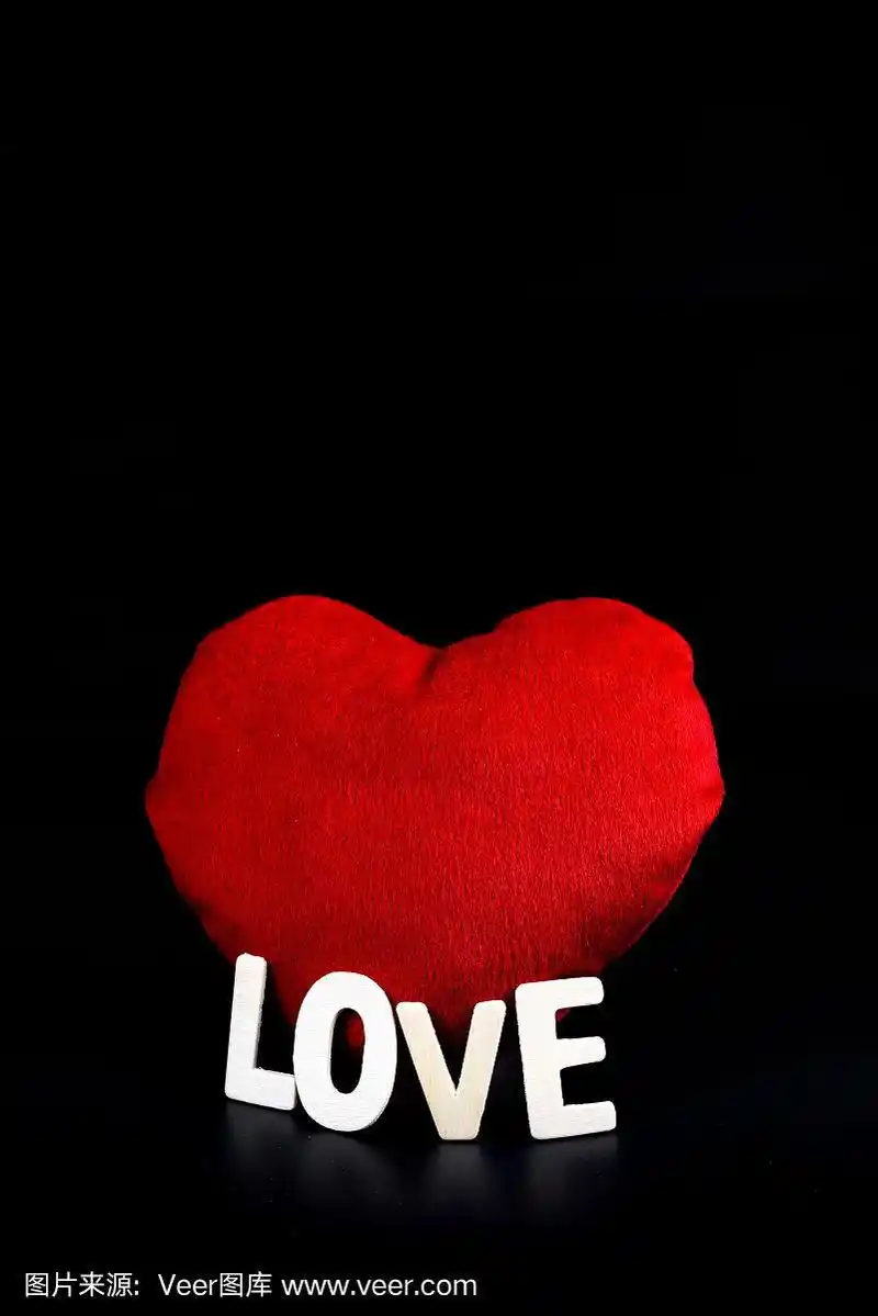 心形和木制字母单词"爱"在黑色的背景