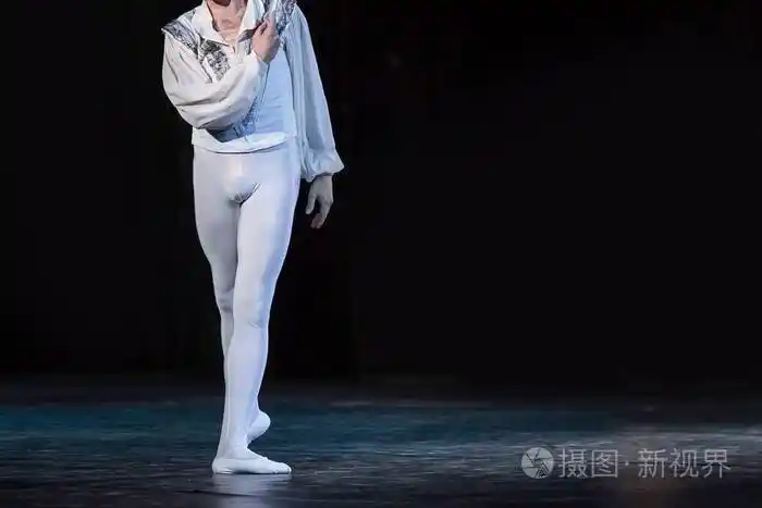 耀眼的白色身影男芭蕾舞与黑暗独自在舞台上跳舞的针线活,裤袜和