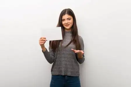 少年女孩在孤立的白色背景上,手里拿着一个空的标语牌,插入一个概念