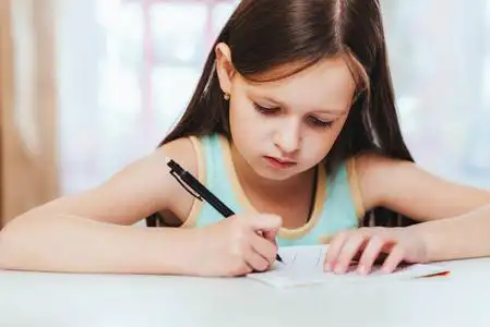 小学是是是这个女孩是第一个在房间里做作业的小学生.照片