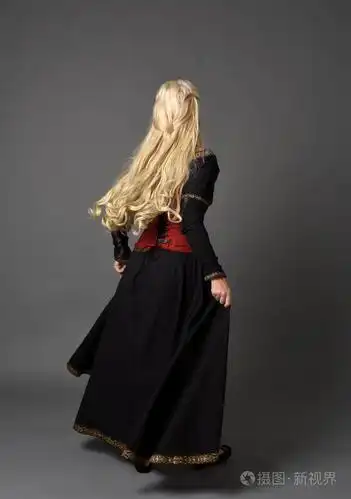 穿红色和黑色中世纪服装的金发女孩全长肖像, 站姿面对远离相机