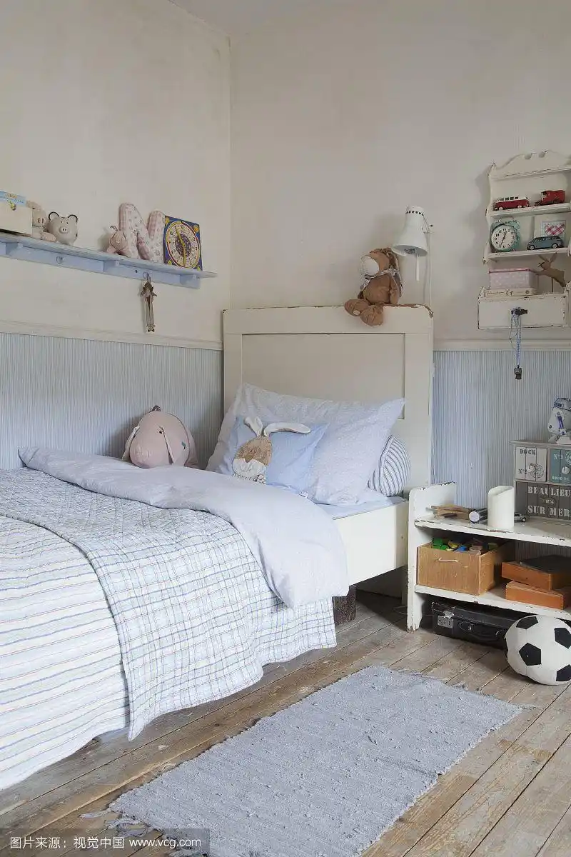 男孩的卧室里,淡蓝色的墙壁和破旧别致的床