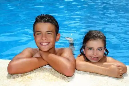 男孩和女孩在游泳池里度暑假照片