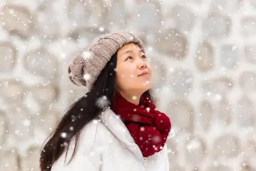 冬天雪花飞舞中向上看女孩